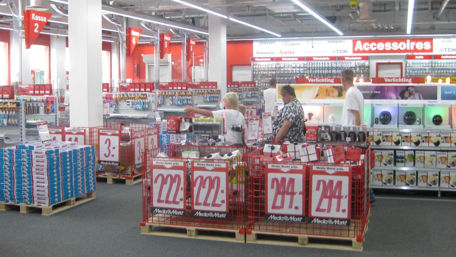 Men and women look at sale goods in Media Markt shop